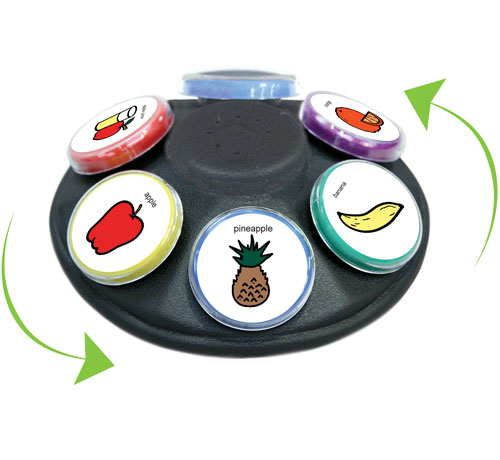 A round six-button communicator on a spinning Lazy Susan base, the wedge-shaped buttons holding colorful picture icons around a central level knob.