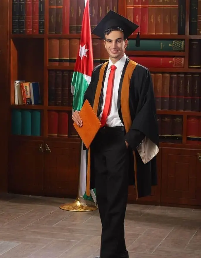 Hasan Tayem smiling in a graduation cap and gown, holding a diploma