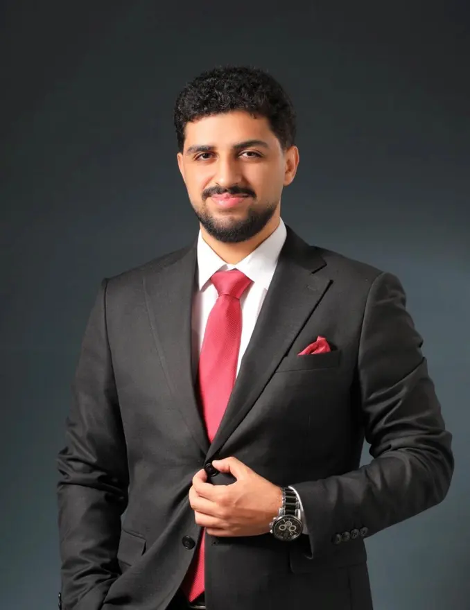Mohamed Salem smiling in a dark suit and red tie